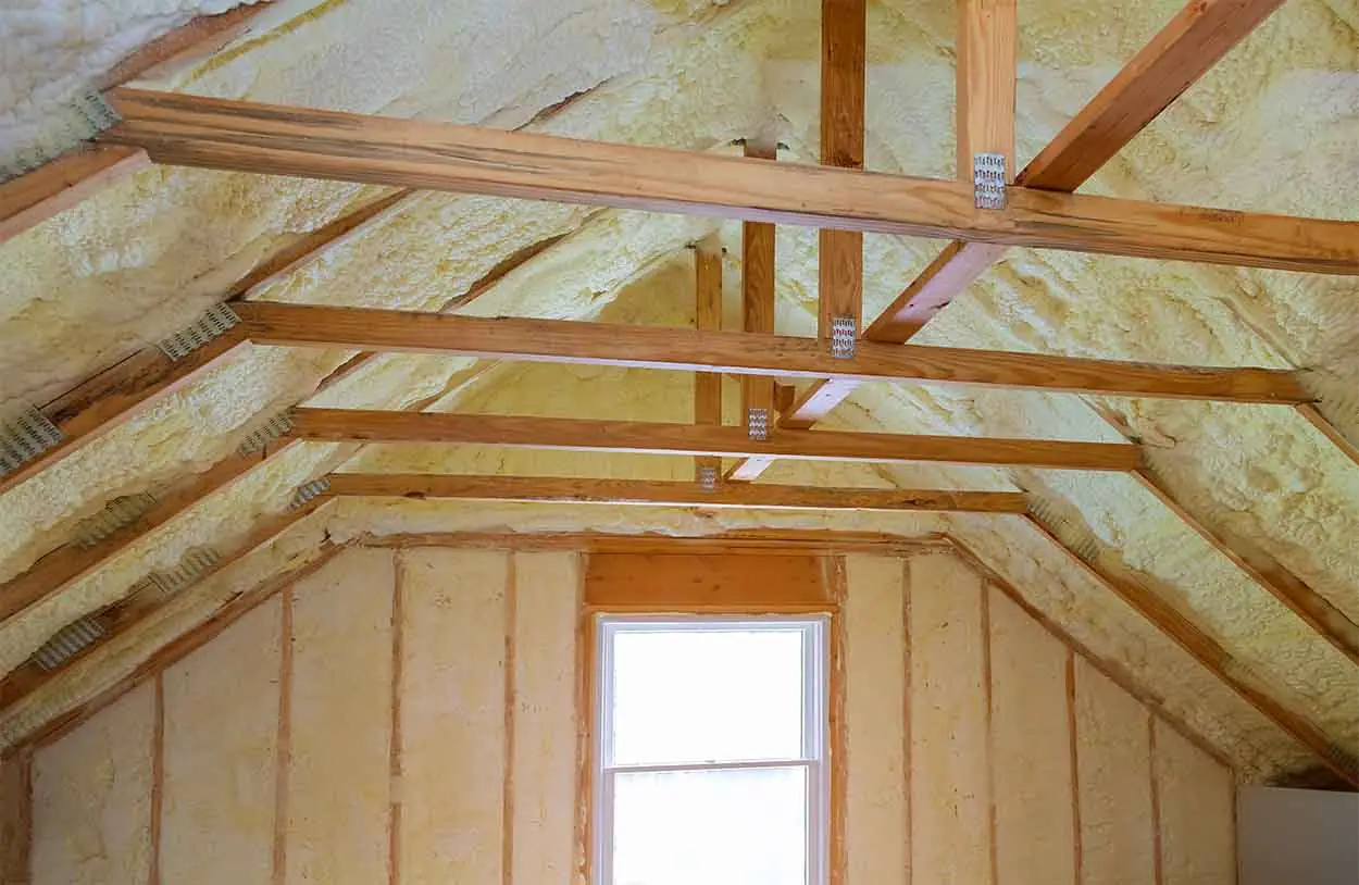 Home's attic with spray foam insulation on walls and ceiling.