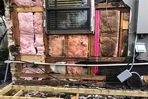 Exterior wall opened up exposing old and moldy insulation that needs to be replaced - residential home
