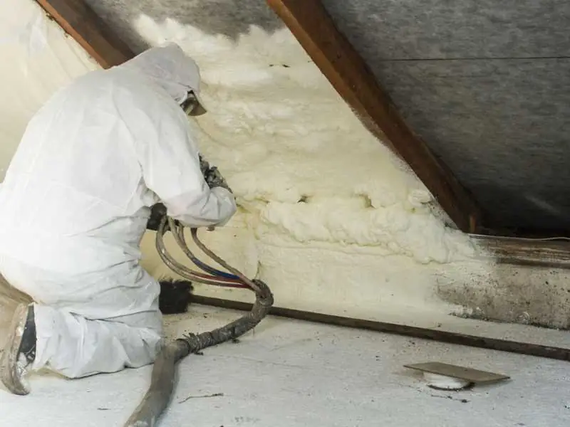 Spray foam insulation installer, insulating attic's walls.